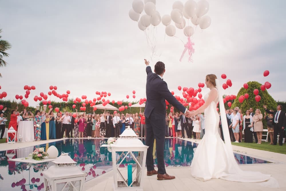 Mariés et invités lors d'un lâcher de ballons pendant la réception d'un mariage